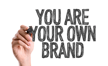 Hand with marker writing You Are Your Own Brand