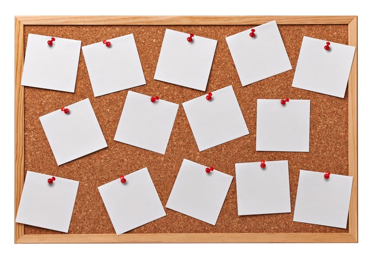 close up of note papers on a cork board